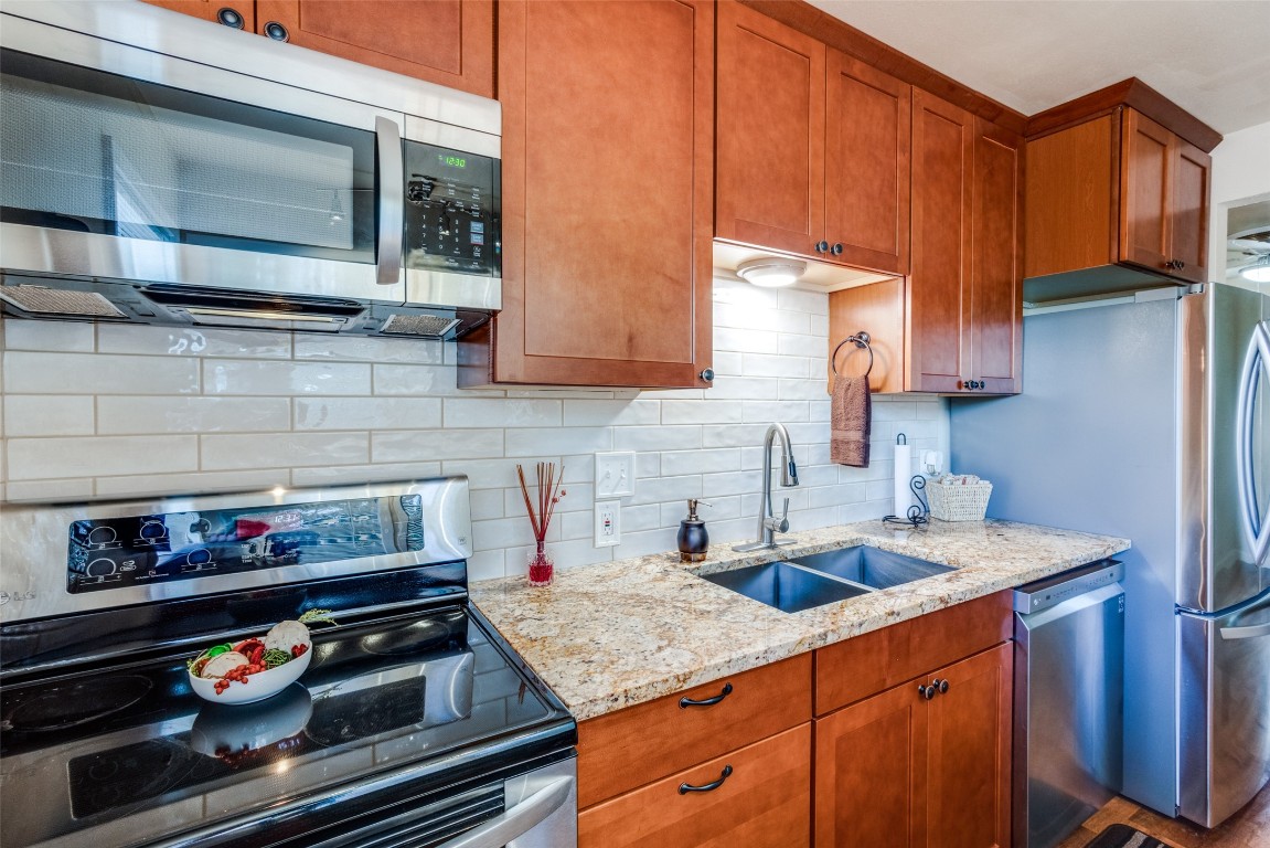 1200 West Phillips Street Alvin, TX 77511 - Photo 7 of 31 a kitchen with stainless steel appliances granite countertop stove top oven and cabinets