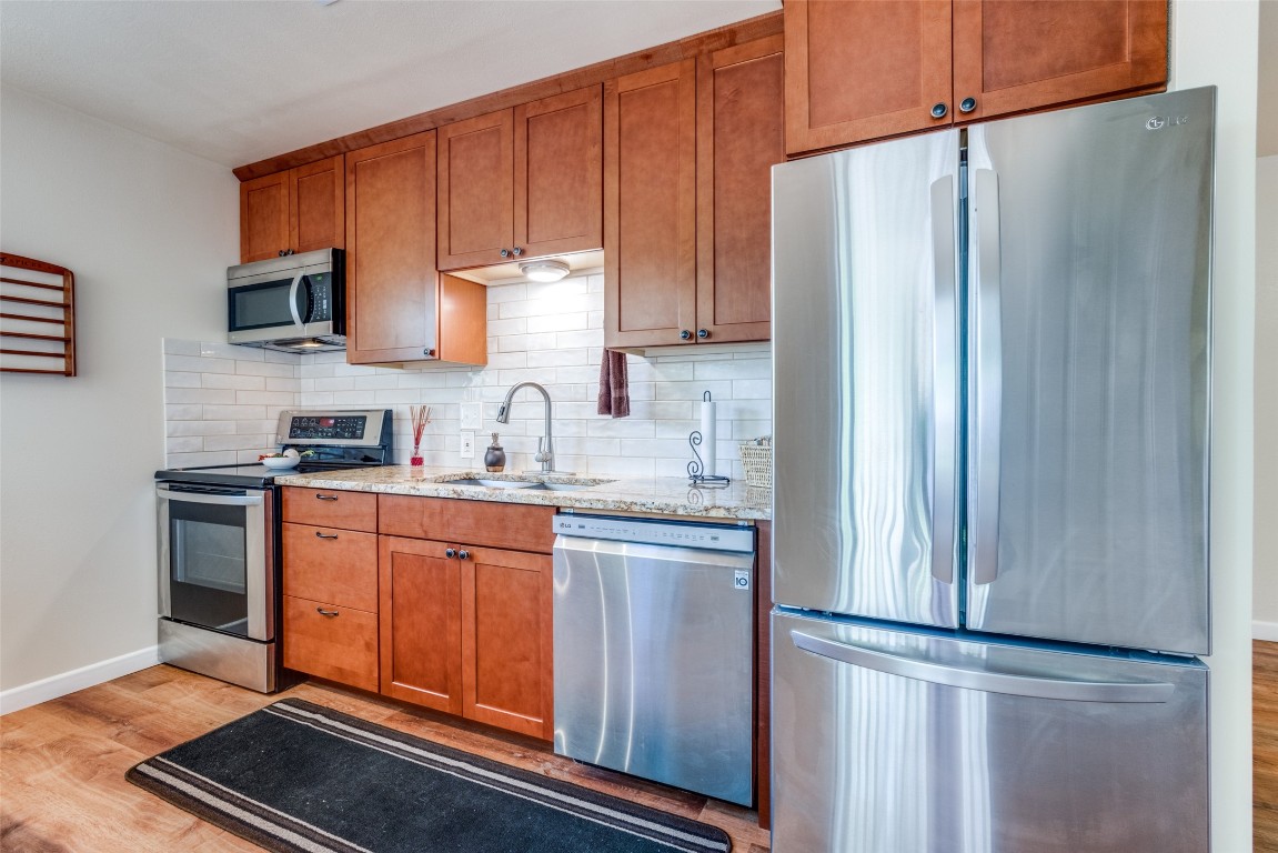 1200 West Phillips Street Alvin, TX 77511 - Photo 8 of 31 a kitchen with stainless steel appliances granite countertop a refrigerator and a stove top oven