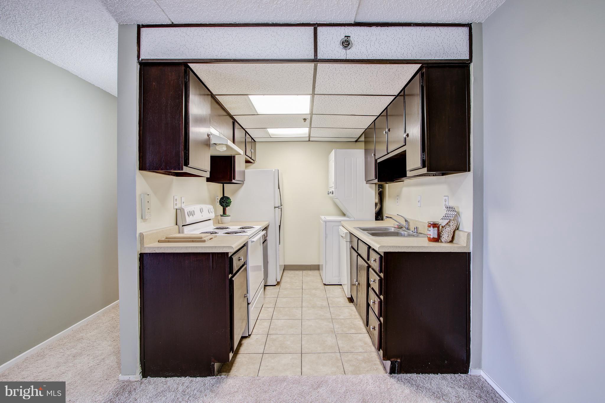 5911 Edsall Road, Unit 902 Alexandria, VA 22304 - Photo 11 of 26 a kitchen with stainless steel appliances a sink stove and cabinets