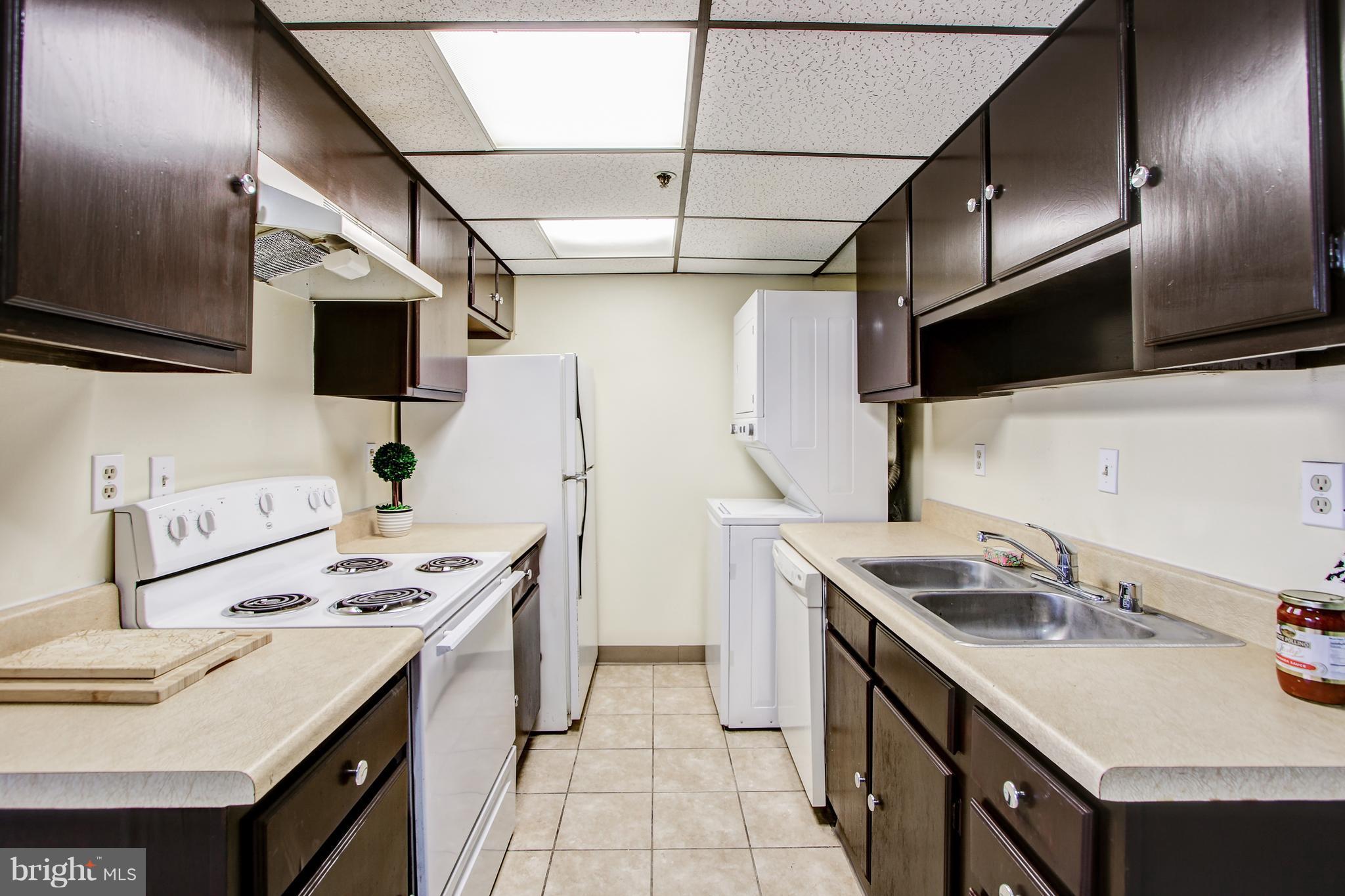 5911 Edsall Road, Unit 902 Alexandria, VA 22304 - Photo 12 of 26 a kitchen that has a sink a stove and a microwave