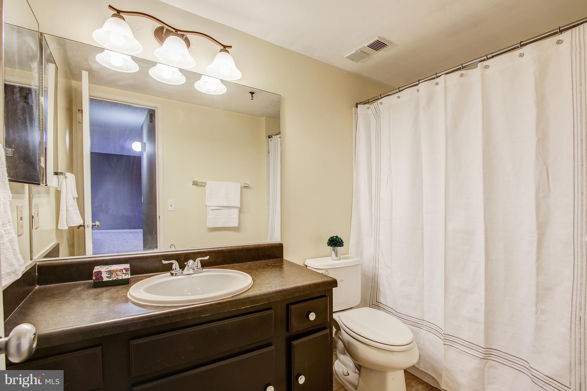 5911 Edsall Road, Unit 902 Alexandria, VA 22304 - Photo 15 of 26 a bathroom with a granite countertop sink toilet and a mirror
