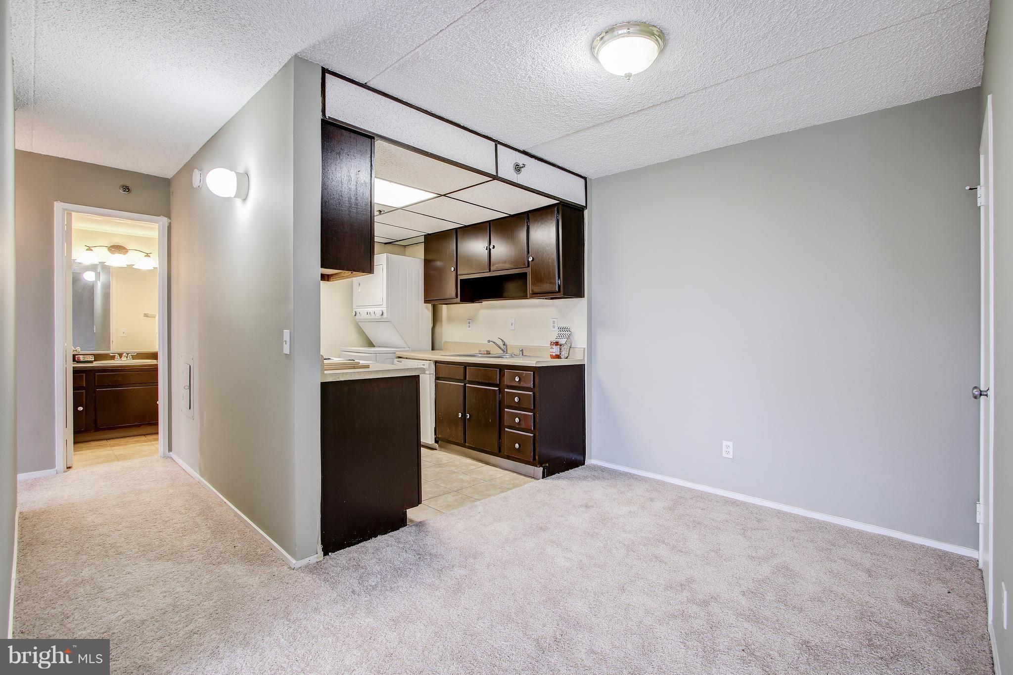 5911 Edsall Road, Unit 902 Alexandria, VA 22304 - Photo 10 of 26 a view of a kitchen with a sink and dishwasher a refrigerator with wooden floor