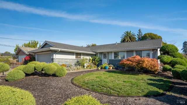 a front view of a house with a garden and plants
