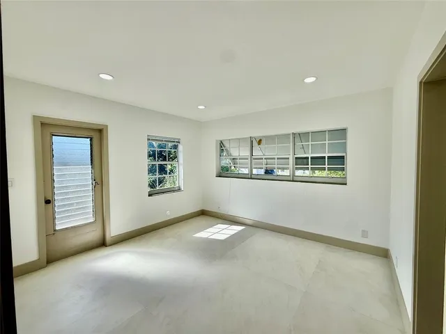 an empty room with window and ceiling fan