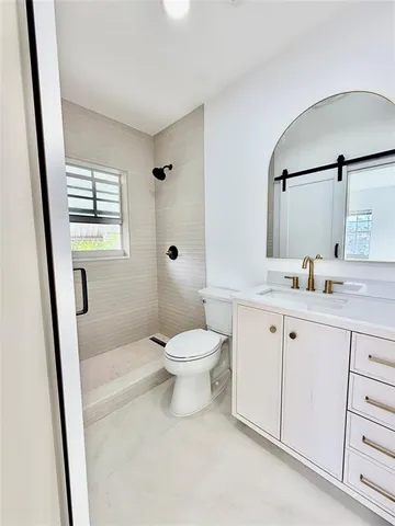 a bathroom with a toilet a sink a mirror and a window