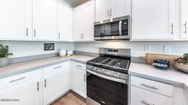 a kitchen with white cabinets and black appliances