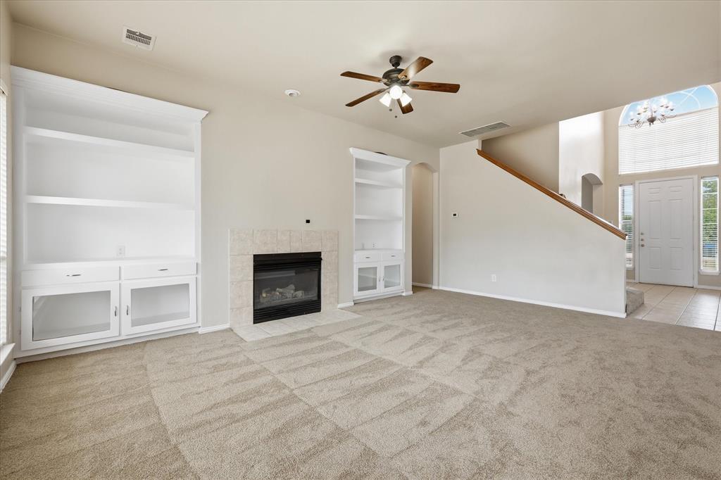 944 Hedgcoxe Road Plano, TX 75025 - Photo 11 of 40 Generously sized second living room open to kitchen. With a wall of windows, built-ins, and a cozy fireplace - this will be the heart of the home