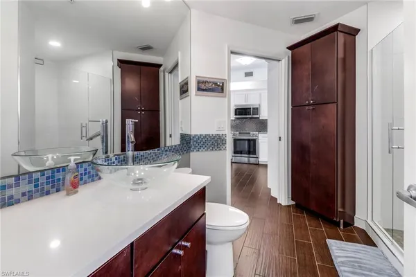 a bathroom with a sink a toilet and shower a mirror