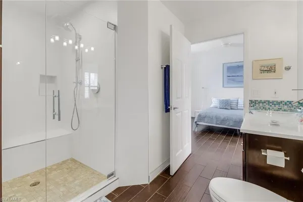 a en suite bathroom with a granite countertop sink and a mirror