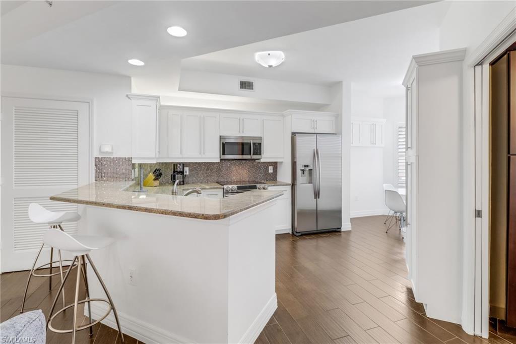 450 Bayfront Place, Unit 4201 Naples, FL 34102 - Photo 4 of 23 a kitchen with stainless steel appliances granite countertop a sink and a refrigerator