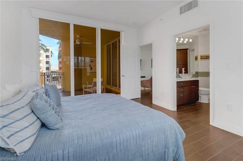 450 Bayfront Place, Unit 4201 Naples, FL 34102 - Photo 10 of 23 a bedroom with a bed and a large mirror