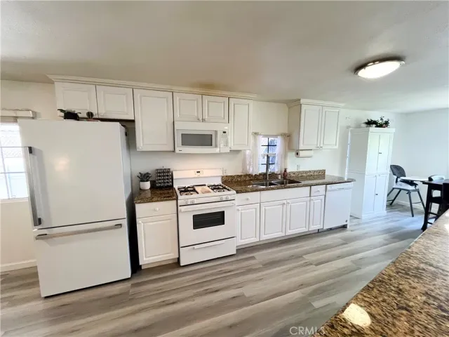 a kitchen with white cabinets and white appliances
