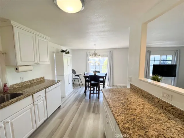 a kitchen with granite countertop white cabinets and stainless steel appliances
