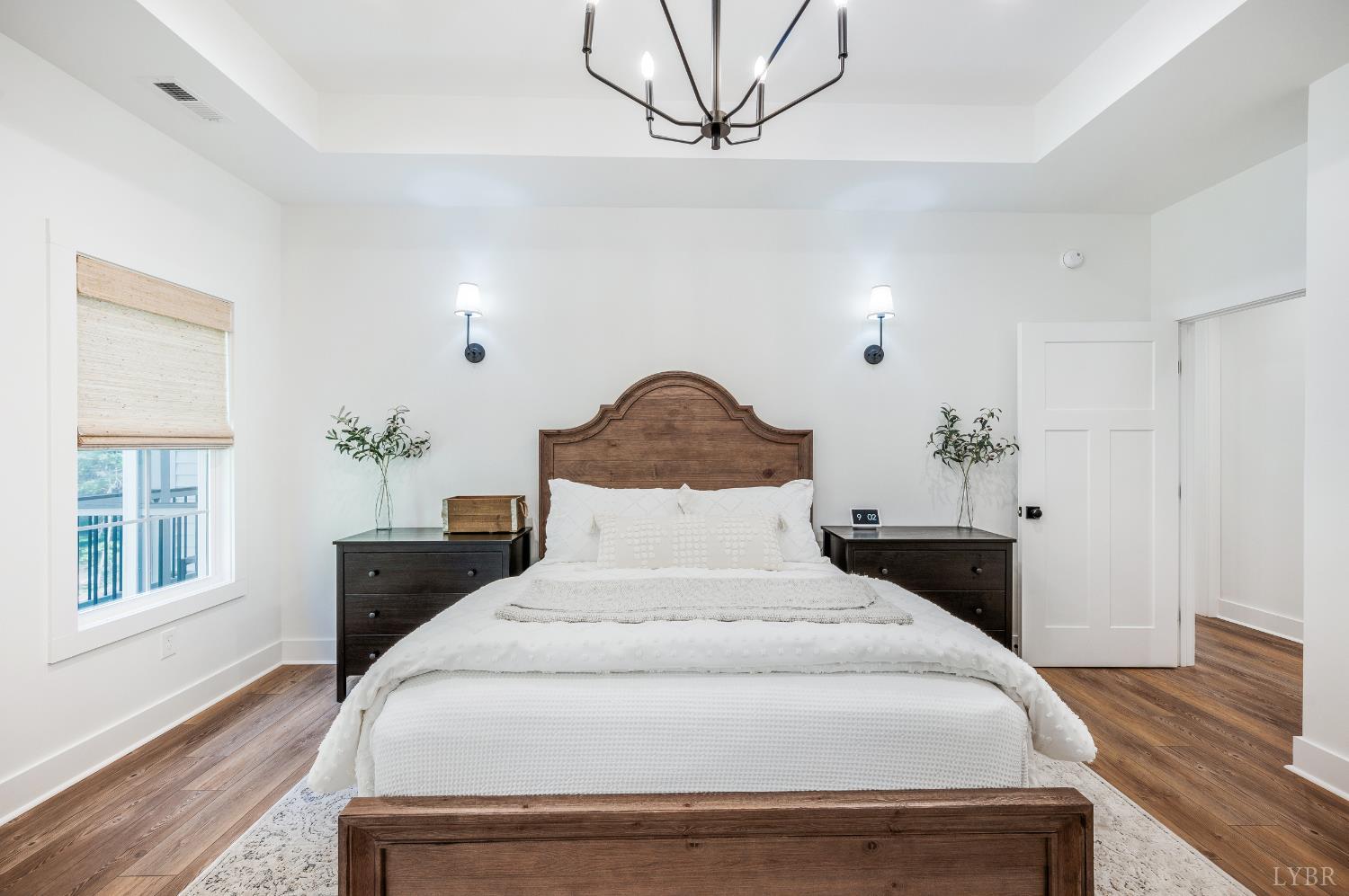 2262 Hooper Road Forest, VA 24551 - Photo 54 of 80 a bedroom with a large bed and a chandelier