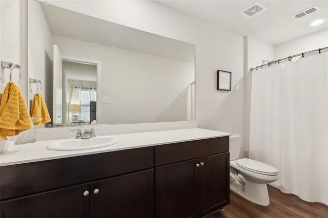 a bathroom with a sink vanity mirror and toilet