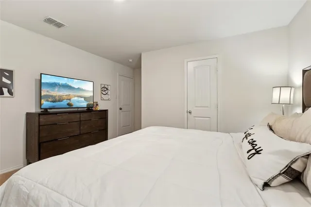 a bedroom with a bed and a flat screen tv