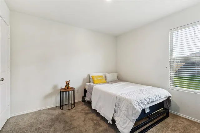 a bed sitting in a bedroom next to a window