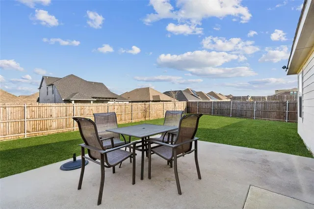 a view of a chairs and table in backyard