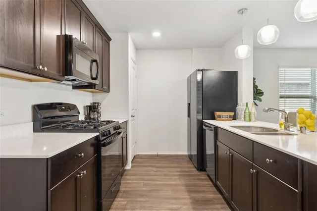a kitchen with stainless steel appliances granite countertop a stove a sink and a refrigerator