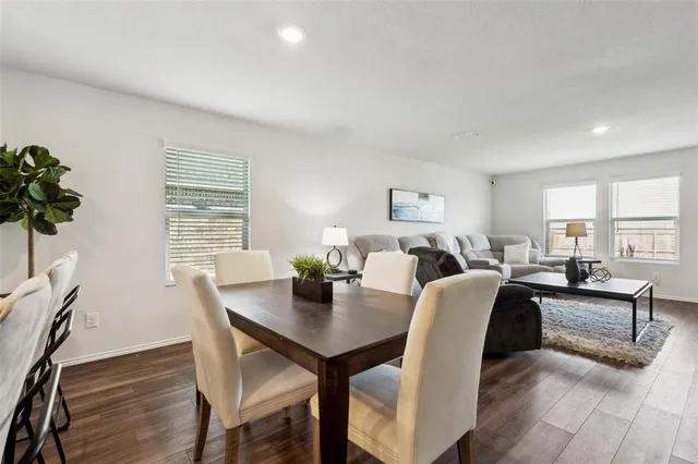 a view of a dining room and livingroom with furniture wooden floor and a rug