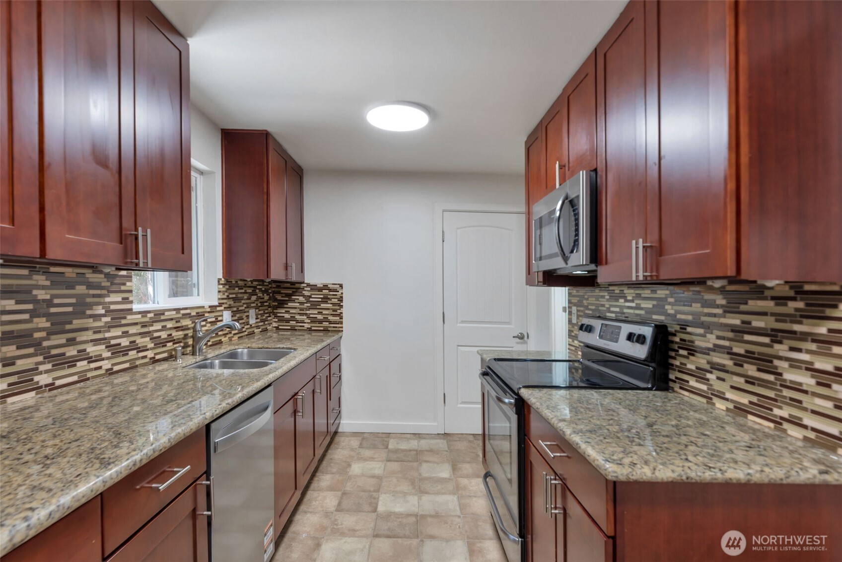 11229 29th Avenue Southwest Seattle, WA 98146 - Photo 7 of 28 a kitchen with granite countertop stainless steel appliances and wooden cabinets