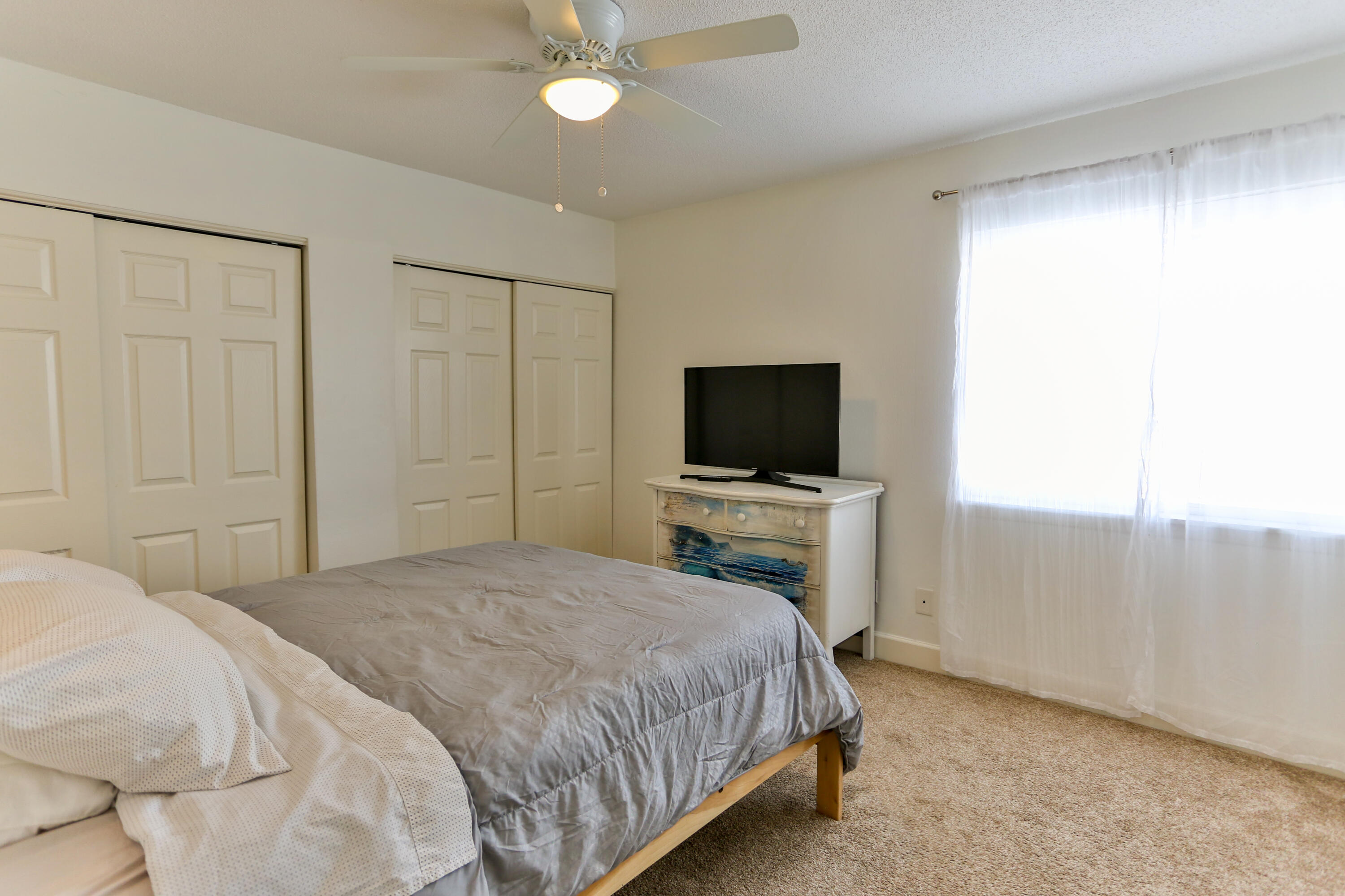 101 Old Ferry Road, Unit 1D Shalimar, FL 32579 - Photo 15 of 34 a bedroom with a bed and a flat screen tv