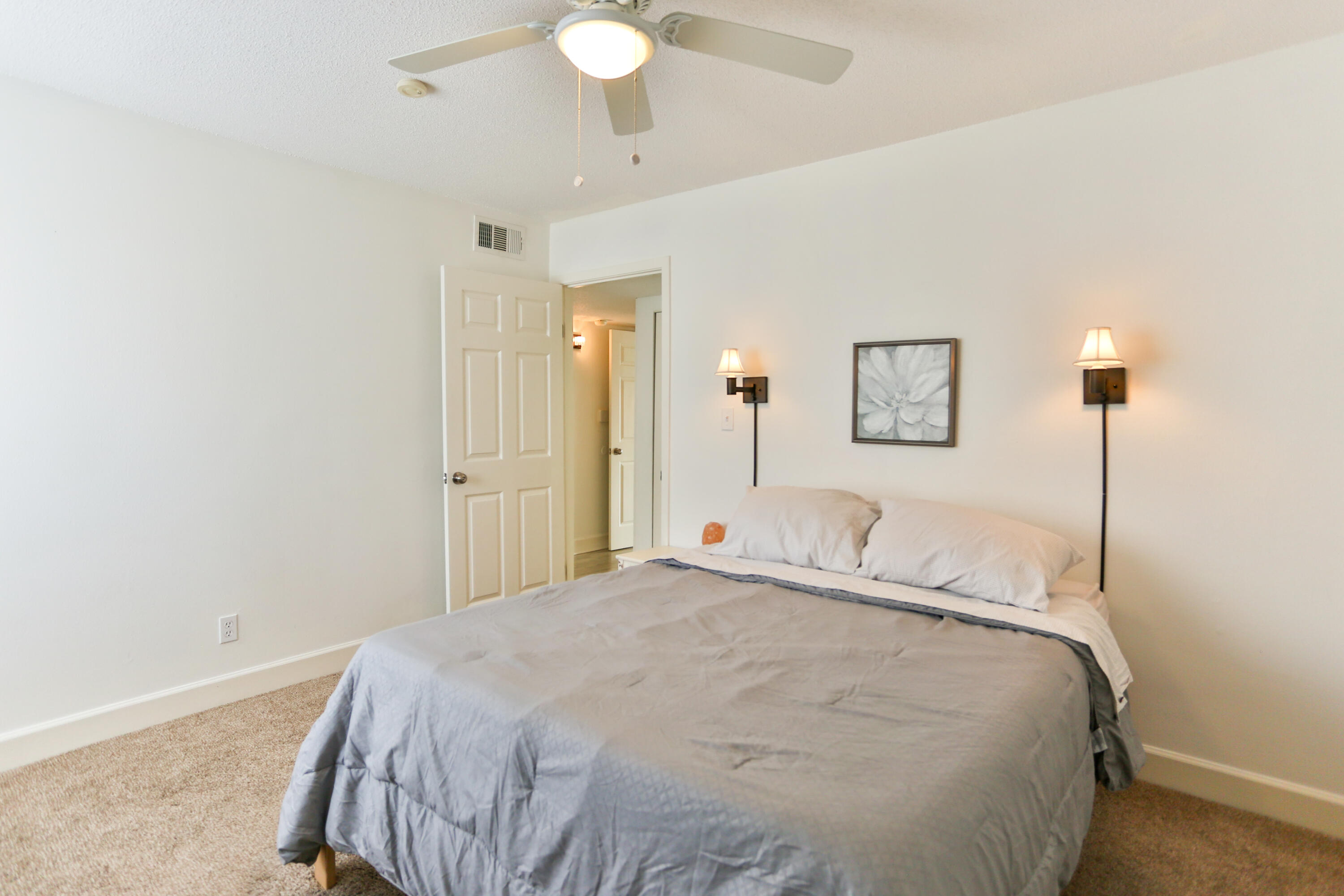 101 Old Ferry Road, Unit 1D Shalimar, FL 32579 - Photo 17 of 34 a bedroom with a bed and a lamp