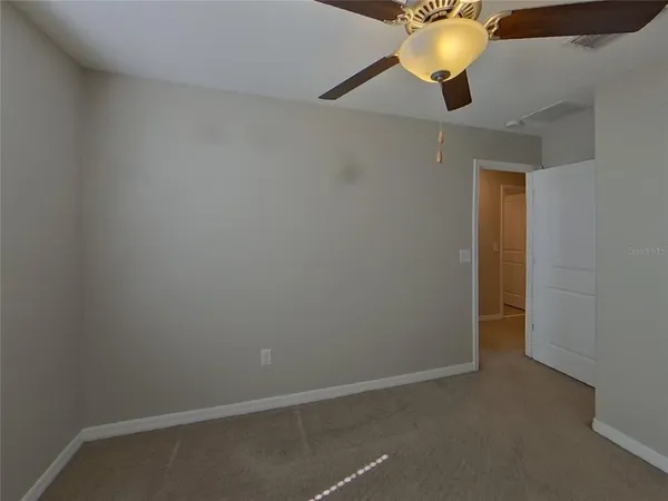 an empty room with a ceiling fan and fan