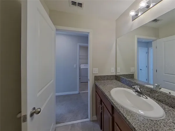 a bathroom with a granite countertop sink and a mirror