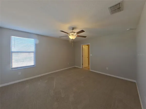 a view of a livingroom with a ceiling fan and window