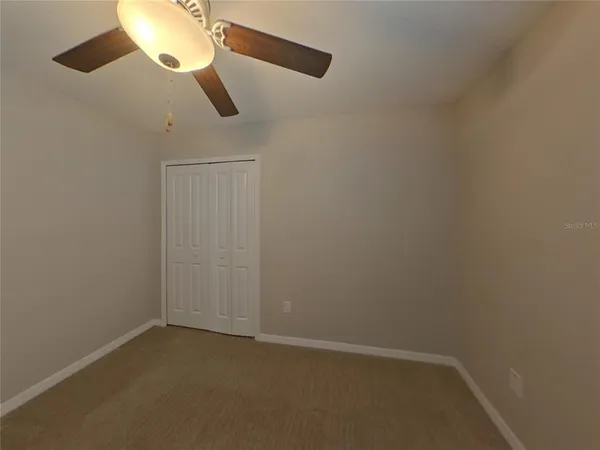 an empty room with a chandelier fan