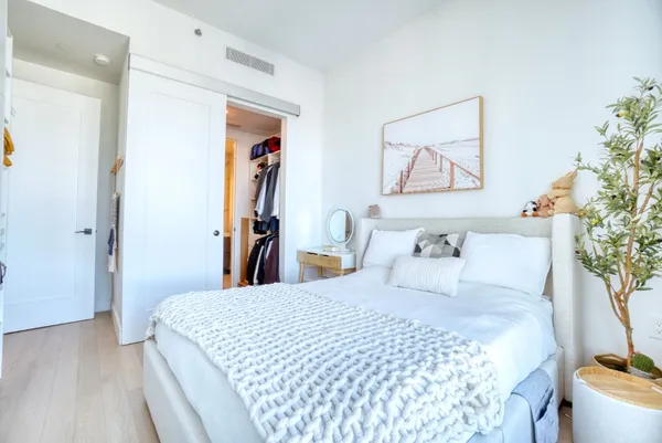 a bedroom with a bed and a painting on the wall