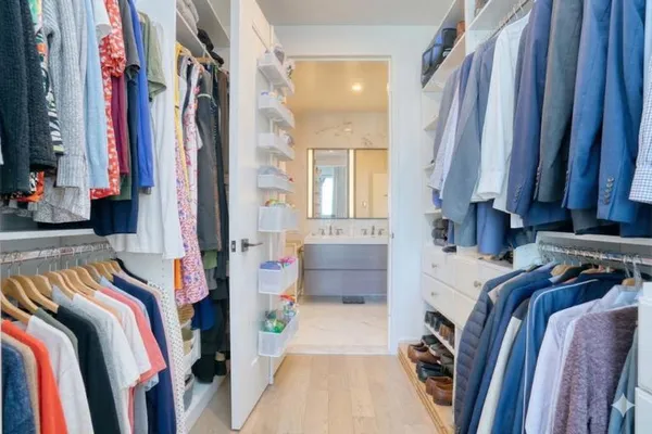 a view of walk in closet with clothes and shoes
