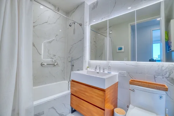 a bathroom with a sink a toilet and shower