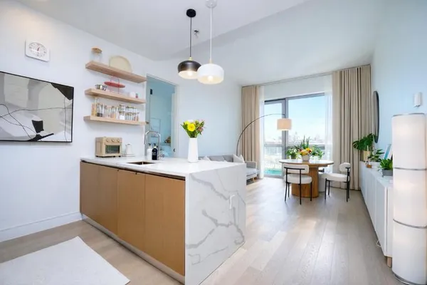 a living room with stainless steel appliances granite countertop furniture a couch and a view of kitchen