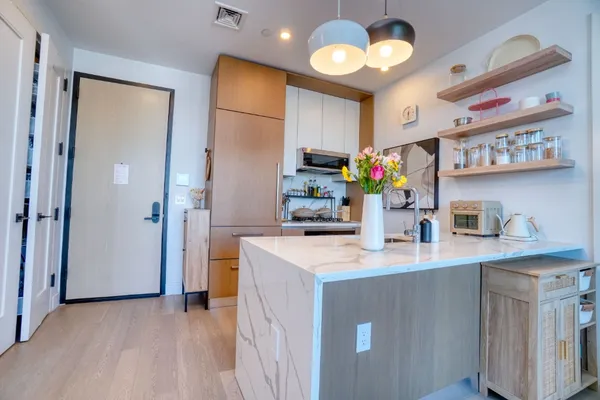 a kitchen that has a lot of cabinets a sink and wooden floor