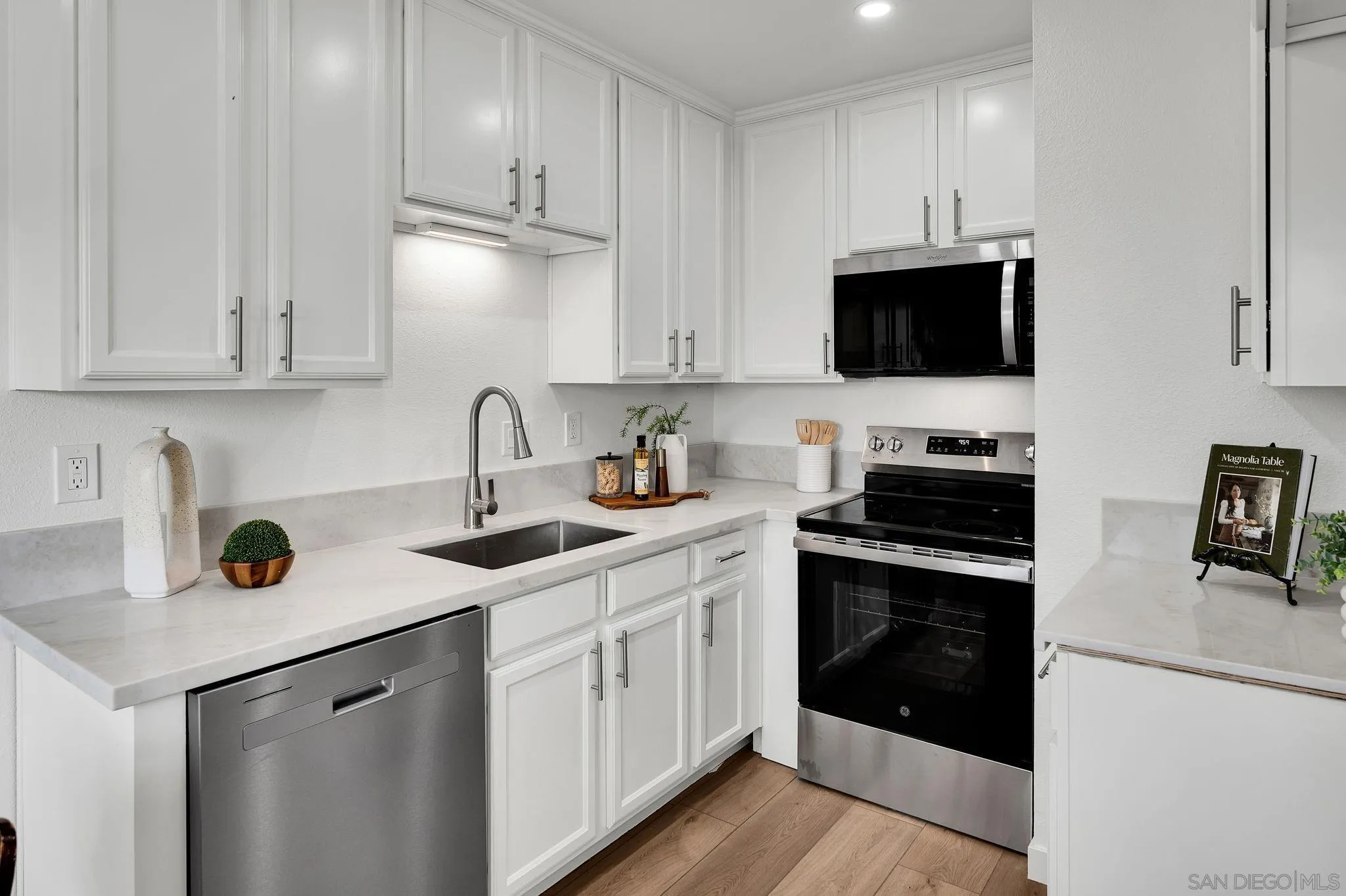 10235 Madrid Way, Unit 108 Spring Valley, CA 91977 - Photo 8 of 22 a kitchen with stainless steel appliances granite countertop a sink a stove and a microwave