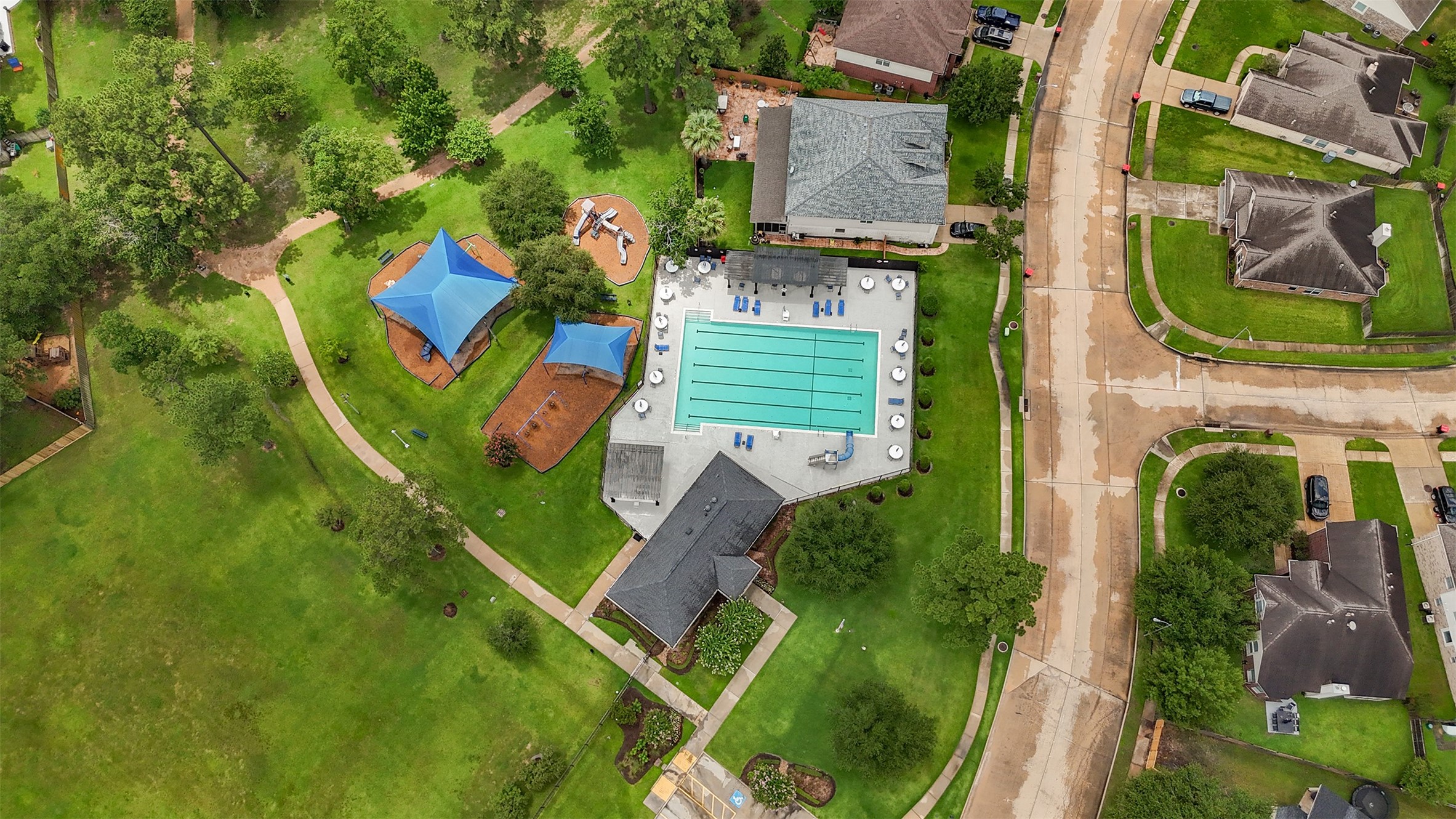 20735 Deauville Drive Spring, TX 77388 - Photo 28 of 33 The neighborhood pool invites you to cool off and unwind in a resort-style setting, while the playground nearby provides a safe, fun space for kids to explore and make lasting memories—all just steps from your backyard gate.