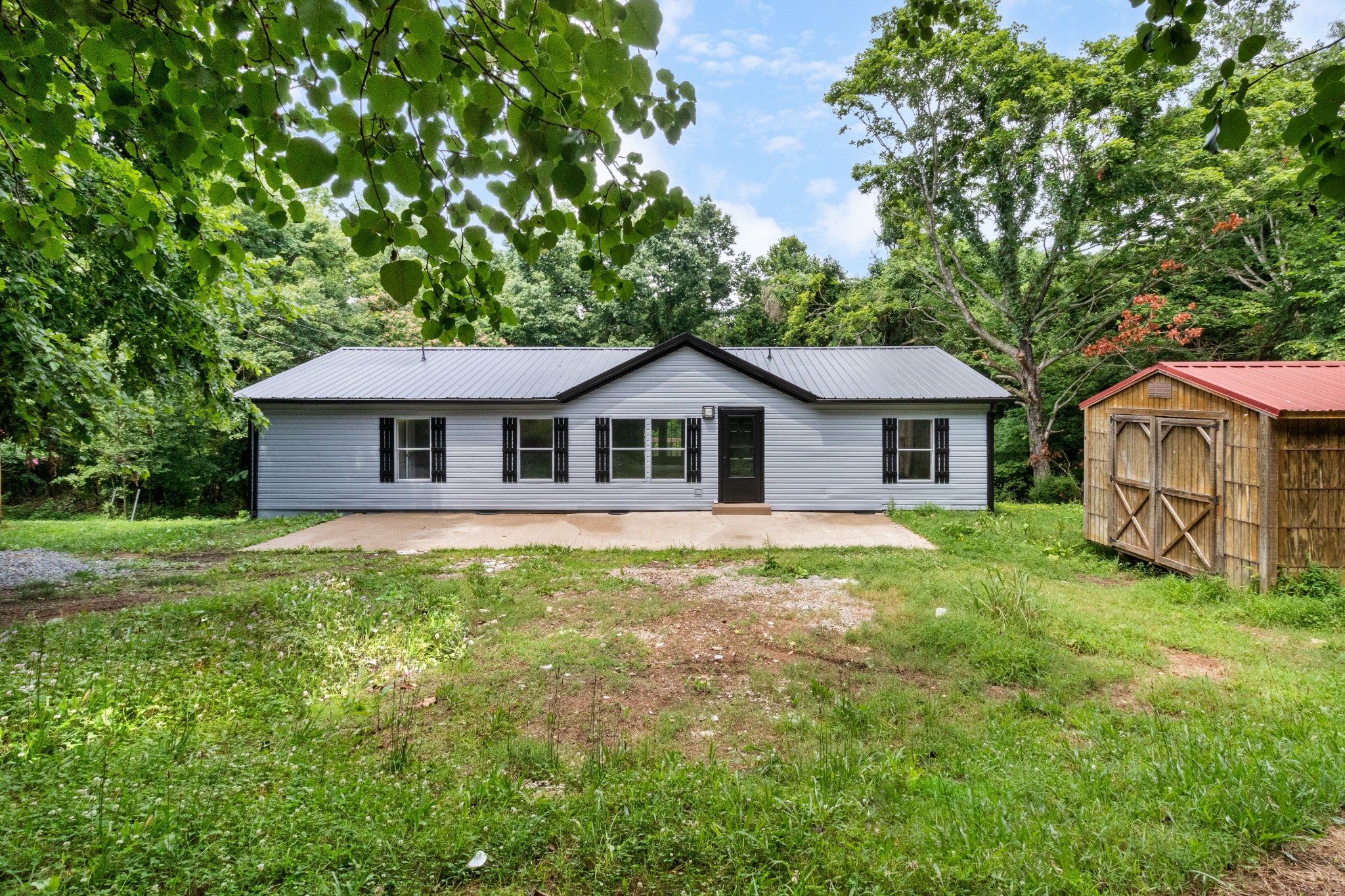 2177 Highway 76 Adams, TN 37010 - Photo 6 of 23 a aerial view of a house next to a yard with potted plants and large tree