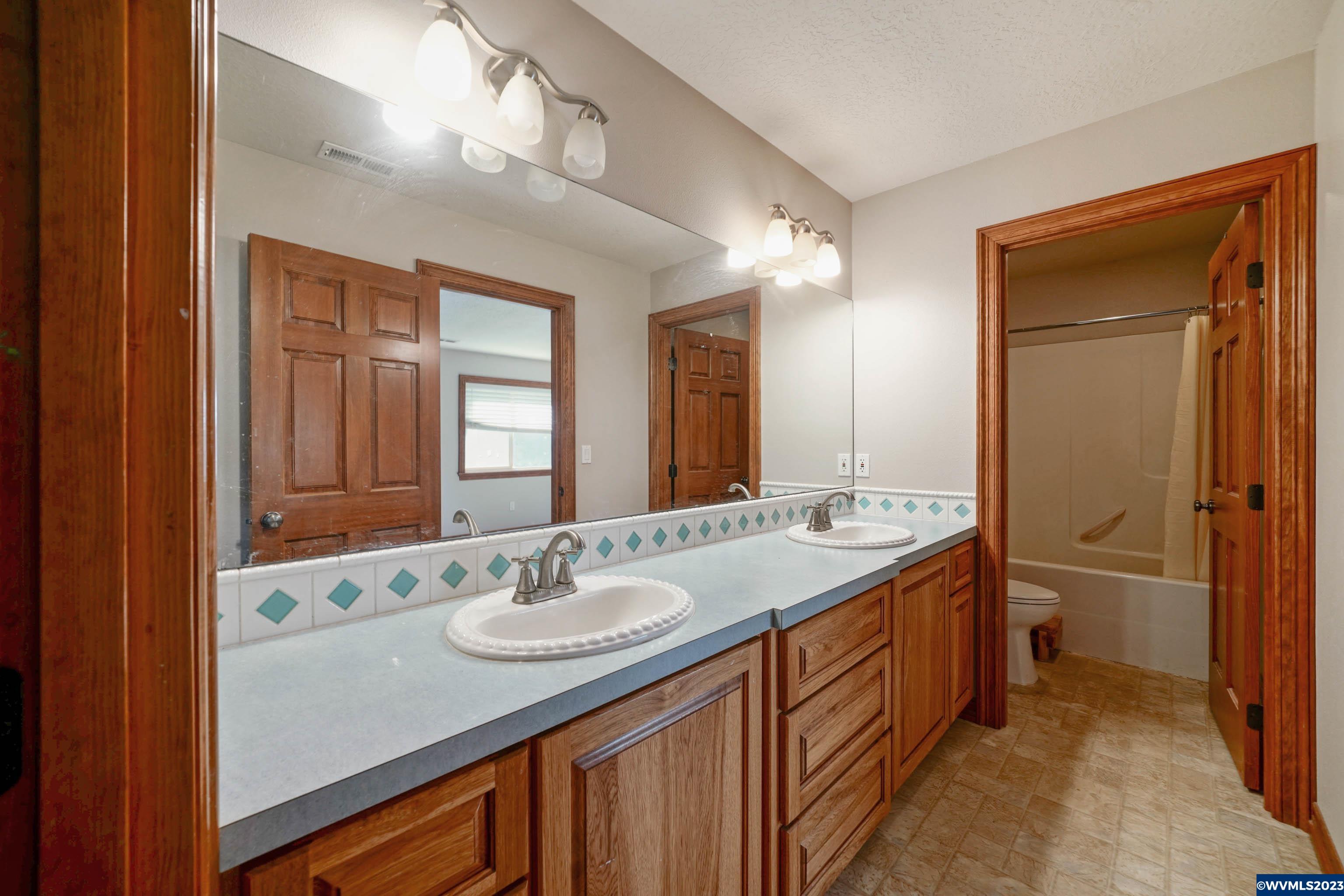 16570 Oakdale Road Dallas, OR 97338 - Photo 33 of 41 a bathroom with a sink double vanity granite tub shower and a mirror