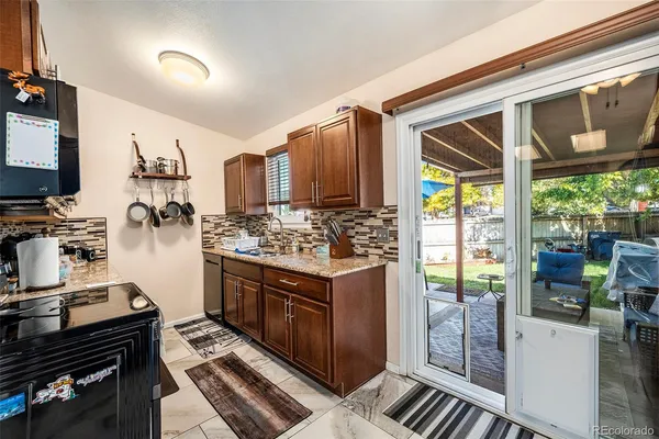 a kitchen with a stove a refrigerator and wooden cabinets