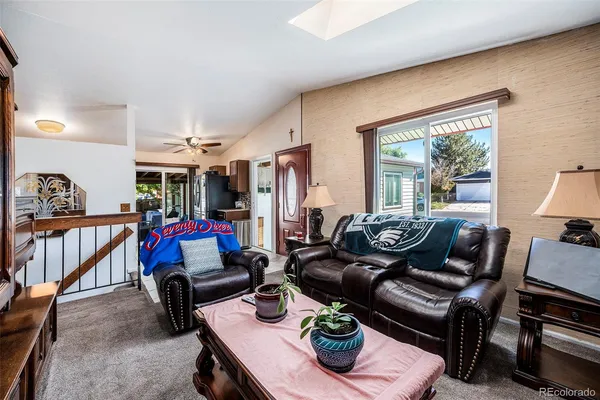 a living room with furniture kitchen view and a window