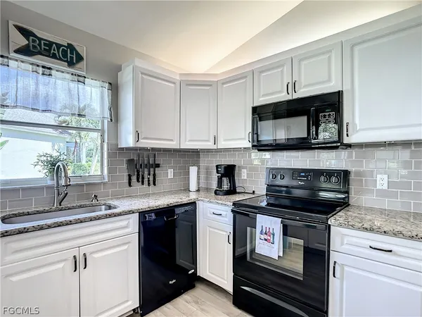 a kitchen with stainless steel appliances kitchen island granite countertop a refrigerator a oven a stove and a sink