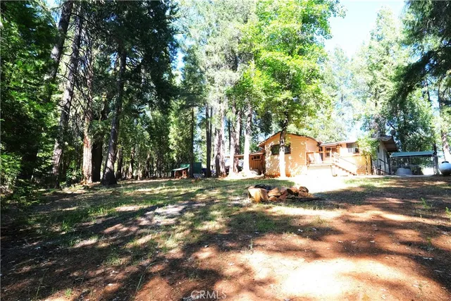 a view of a house with backyard and trees