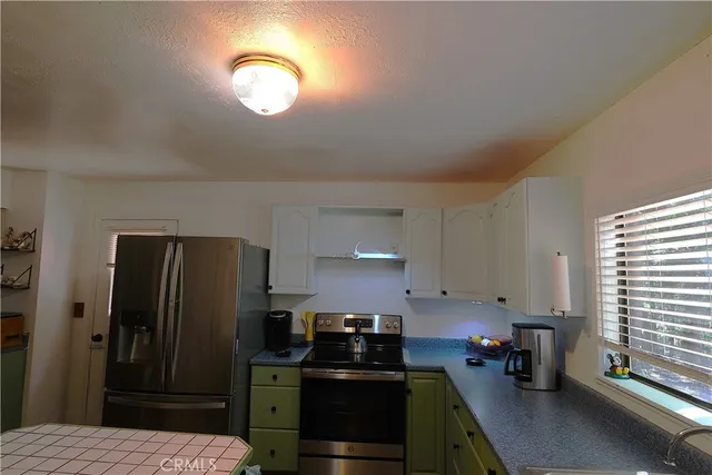 a kitchen with a refrigerator and a stove top oven