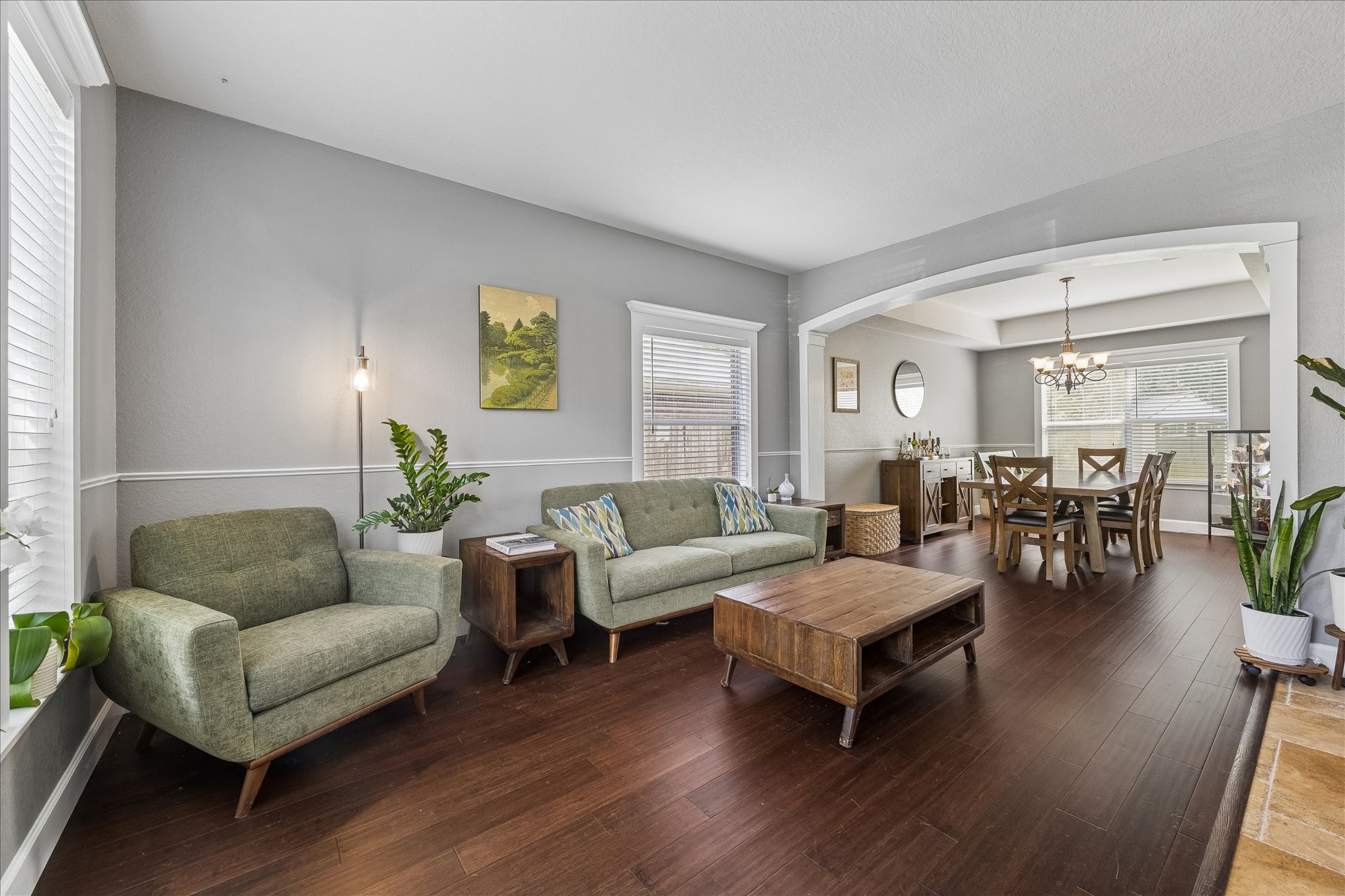 23234 Grand Rapids Lane Spring, TX 77373 - Photo 5 of 30 Sunlit living space showcases a wall of windows, warm wood floors, and stylish furnishings creating an inviting atmosphere.