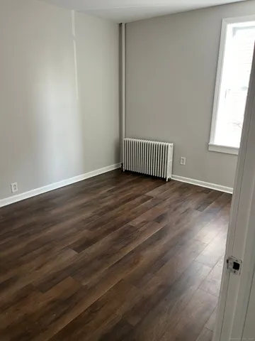 a view of a hallway with wooden floor and a window