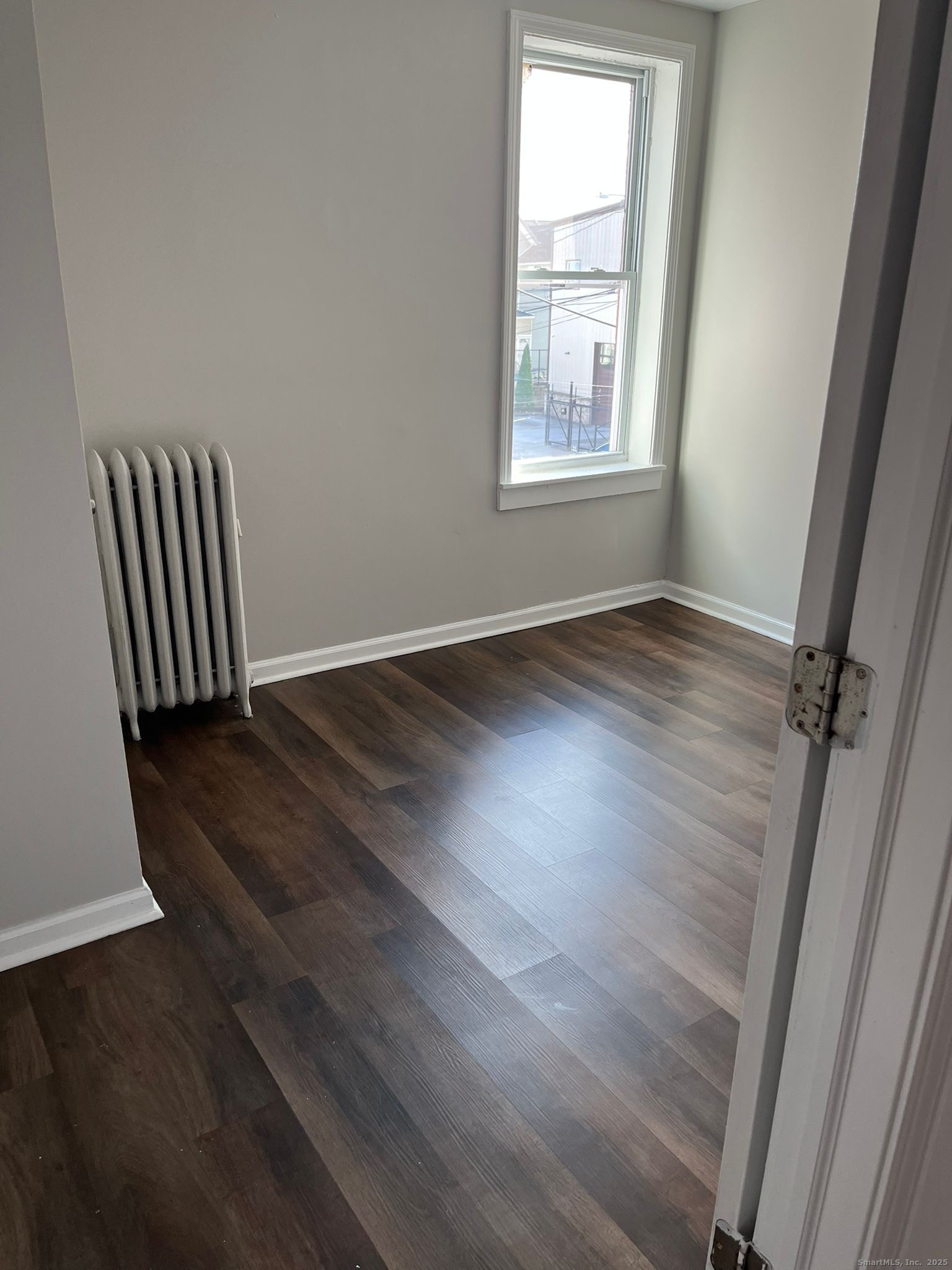 146 George Street, Unit 2 Bridgeport, CT 06604 - Photo 4 of 7 an empty room with wooden floor and windows