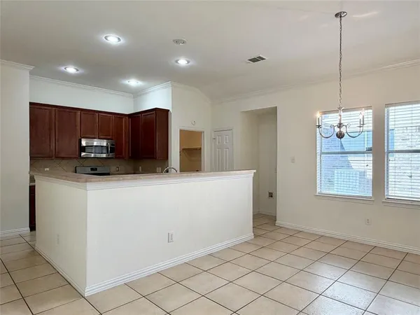 a view of kitchen with granite countertop cabinets and refrigerator