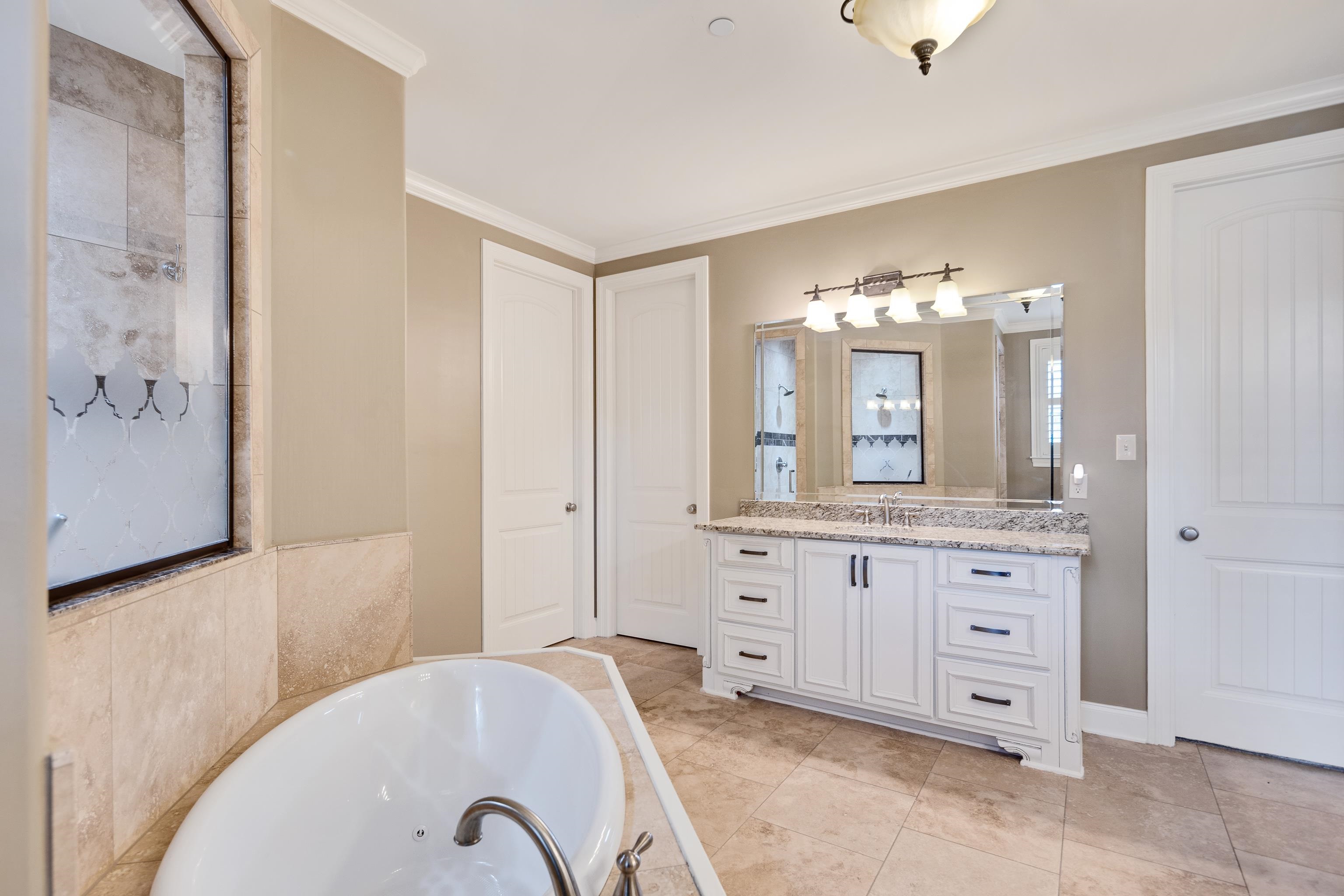 250 Ridgewood Drive Piperton, TN 38017 - Photo 14 of 36 a spacious bathroom with a granite countertop sink a mirror and a bathtub